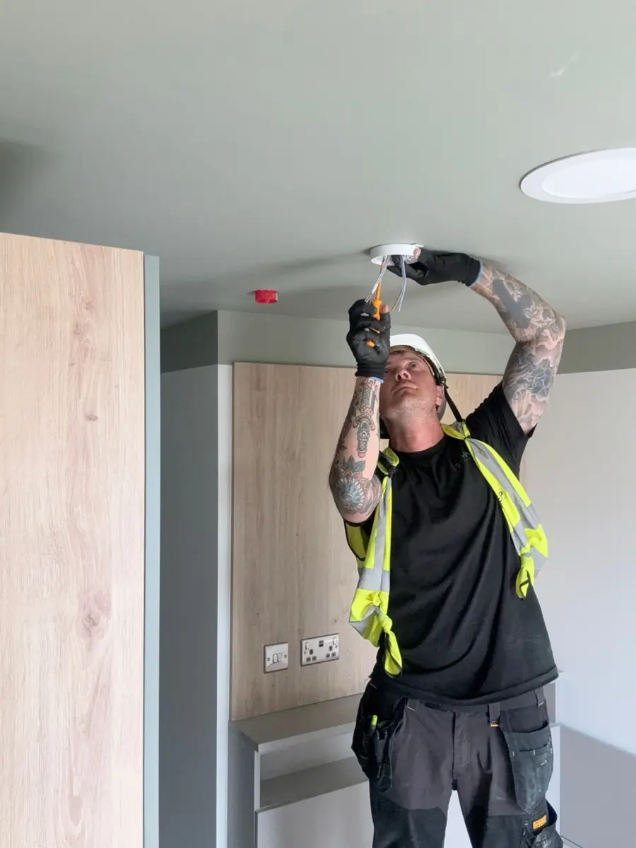 Carl from Denham Electrical fitting a ceiling light